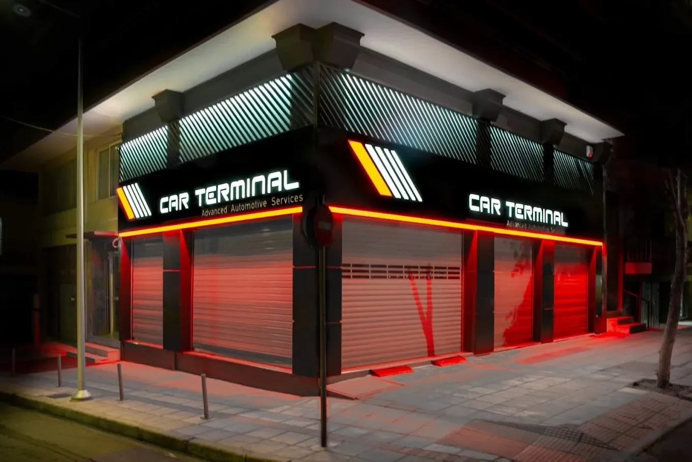 Η πρόσοψη του εργαστηρίου Car Terminal τη νύχτα, με φωτισμένη επιγραφή και κόκκινο φωτισμό